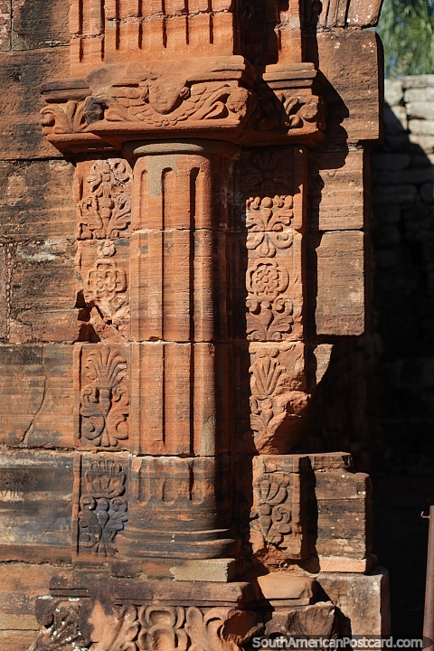 Columna de piedra con flores, remolinos y figuras a su alrededor, una cara en la parte superior, ruinas jesuticas, San Ignacio. (480x720px). Argentina, Sudamerica.