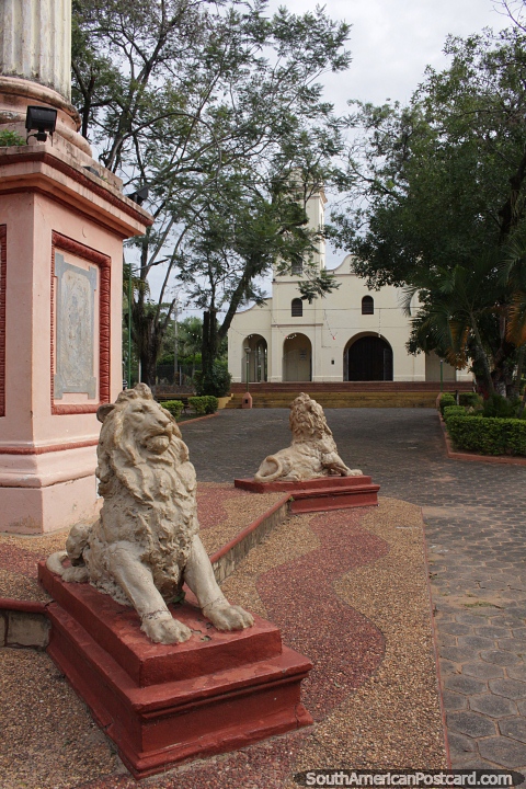 Gold lions and the cathedral at the plaza in Carapegua. (480x720px). Paraguay, South America.