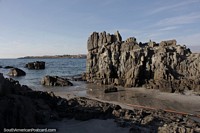 Wall of rough jagged rock meets the seafront in Caldera.