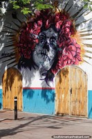 Verso maior do Mural atraente de um rosto assustador com cabelo rosa vermelho em Santa Marta.