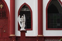 ngel frente a las ventanas, columnas y puerta marrones de la Parroquia Nuestra Seora del Carmen en Honda.