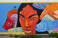 Indigenous man and colorful fish, street art in Honda.