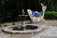 Fish made from tiles and a stone fountain in small park Honda.