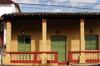 Old colonial building nicely painted with green wooden doors in Caacupe.